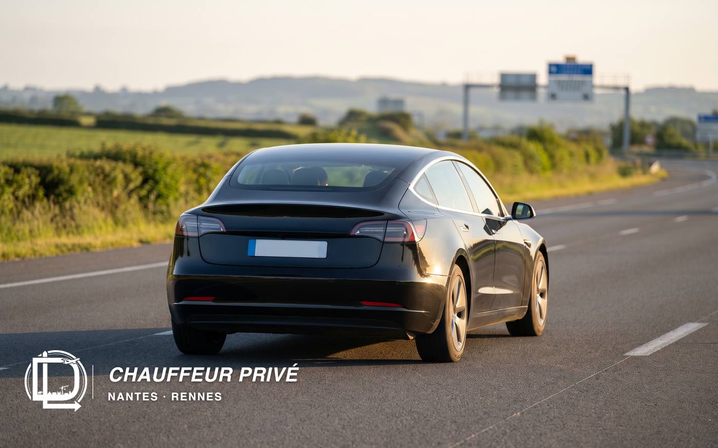 Berline Tesla noire sur une voie rapide entre Nantes et Rennes, en fin d'après-midi