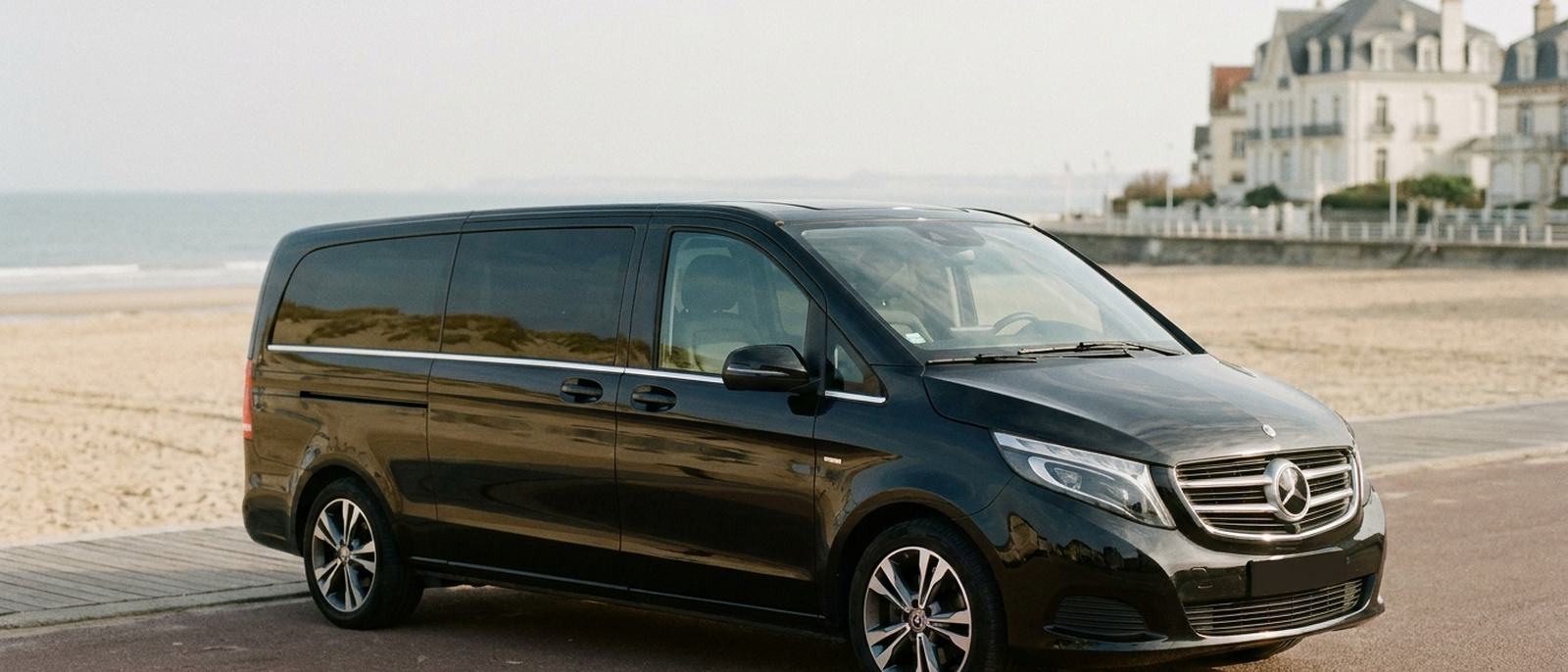Van noir avec chauffeur stationné le long du front de mer d'une station balnéaire atlantique